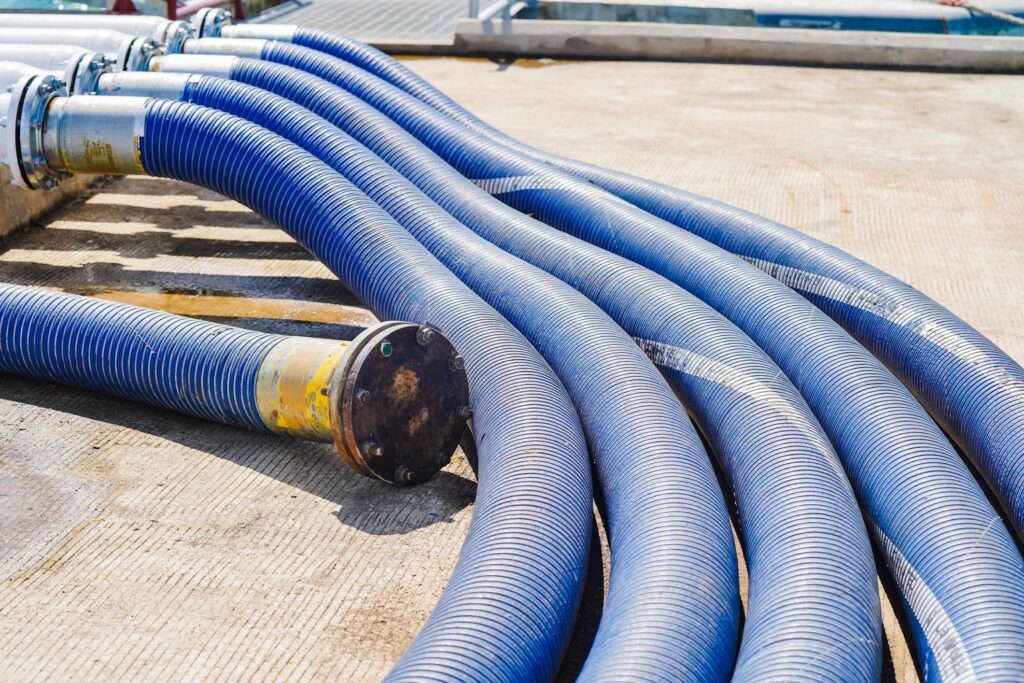Mangueras industriales azules de succión y descarga con conexiones bridadas.